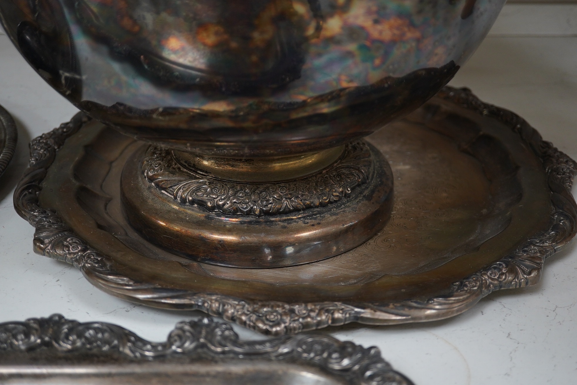 A collection of silver plate comprising large punchbowl, three plated ladles and three plated trays, punchbowl 43cm diameter. Condition - fair, worn